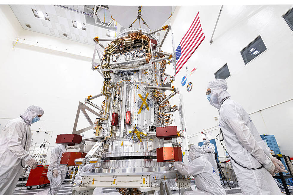 Engineers and technicians inspect the main body of NASA’s Europa Clipper spacecraft