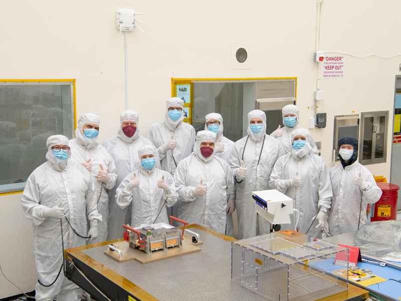 Engineers giving thumbs ups following initial inspections of Europa Clipper's ultraviolet spectrograph in a cleanroom at NASA's Jet Propulsion Laboratory in Southern California.