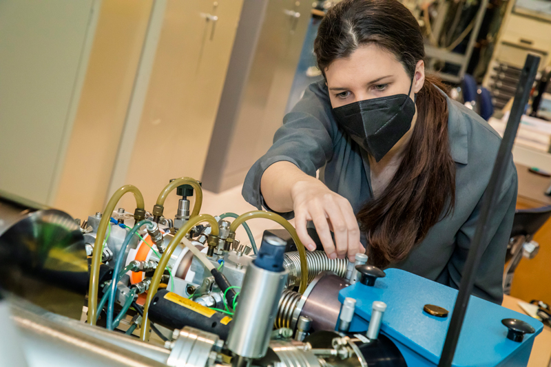 Adjusting laboratory equipment used to calibrate Europa Clipper’s ultraviolet spectrograph.
