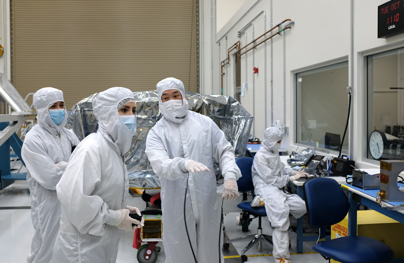 In a clean room at NASA’s Jet Propulsion Laboratory, Mana Salami, guidance and control (G&amp;C) systems engineer (front left) and Herrick Chang, cognizant engineer (front right), discuss testing for Europa Clipper’s star tracker. At far left is G&amp;C hardware engineer Gabrielle Massone. At far right sits quality assurance engineer Shaunessy Grant. Chang, Massone, Grant, and James Alexander (not pictured) escorted the hardware from the Sodern company in France to JPL. 
