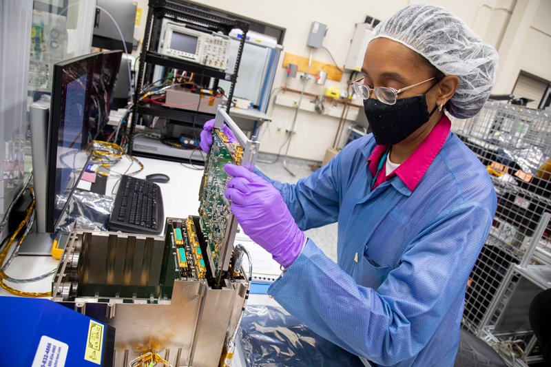 Image showing Southwest Research Institute (SwRI) Staff Engineer Yvette Tyler performs integration and testing on the electronics box for Europa Clipper’s mass spectrometer. The mass spectrometer will analyze gases in Europa’s faint atmosphere and possible plumes. It will study the chemistry of the moon’s suspected subsurface ocean, how ocean and surface exchange material, and how radiation alters compounds on the moon’s surface.