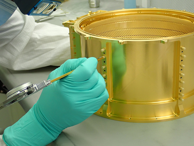 Marc Miller, a mechanical assembly technician at the University of Colorado Boulder Laboratory for Atmospheric and Space Physics (LASP), gauges the depth of ceramic pins installed in the SUrface Dust Analyzer (SUDA) instrument. 