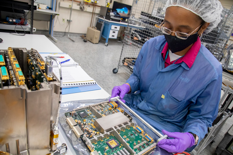 Image showing Southwest Research Institute (SwRI) Staff Engineer Yvette Tyler performs integration and testing on the electronics box for Europa Clipper’s mass spectrometer. The mass spectrometer will analyze gases in Europa’s faint atmosphere and possible plumes. It will study the chemistry of the moon’s suspected subsurface ocean, how ocean and surface exchange material, and how radiation alters compounds on the moon’s surface. 