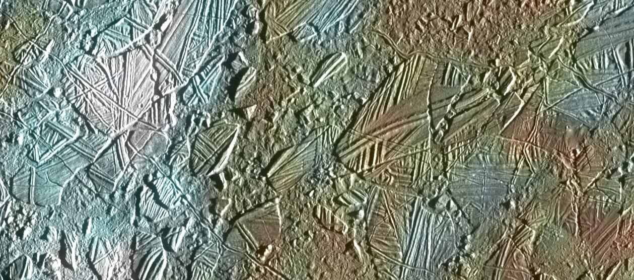View of a small region of the thin, disrupted, ice crust in the Conamara region of Jupiter's moon Europa showing the interplay of surface color with ice structures. The white and blue colors outline areas that have been blanketed by a fine dust of ice particles ejected at the time of formation of the large (26 kilometer in diameter) crater Pwyll some 1000 kilometers to the south. A few small craters of less than 500 meters or 547 yards in diameter can be seen associated with these regions. These were probably formed, at the same time as the blanketing occurred, by large, intact, blocks of ice thrown up in the impact explosion that formed Pwyll. The unblanketed surface has a reddish brown color that has been painted by mineral contaminants carried and spread by water vapor released from below the crust when it was disrupted. The original color of the icy surface was probably a deep blue color seen in large areas elsewhere on the moon. The colors in this picture have been enhanced for visibility. North is to the top of the picture and the sun illuminates the surface from the right. The image, centered at 9 degrees north latitude and 274 degrees west longitude, covers an area approximately 70 by 30 kilometers (44 by 19 miles), and combines data taken by the Solid State Imaging (CCD) system on NASA's Galileo spacecraft during three of its orbits through the Jovian system. Low resolution color (violet, green, and infrared) data acquired in September 1996, were combined with medium resolution images from December 1996, to produce synthetic color images. These were then combined with a high resolution mosaic of images acquired on February 20th, 1997 at a resolution of 54 meters (59 yards) per picture element and at a range of 5340 kilometers (3320 miles).