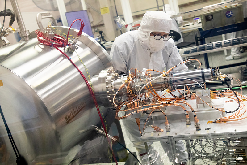 Southwest Research Institute (SwRI)’s Dan Aaron (lead spectrometer technician) is making final adjustments to the electrical connections between the MAss Spectrometer for Planetary EXploration/Europa (MASPEX) EBox and the spectrometer prior to flight model calibration.