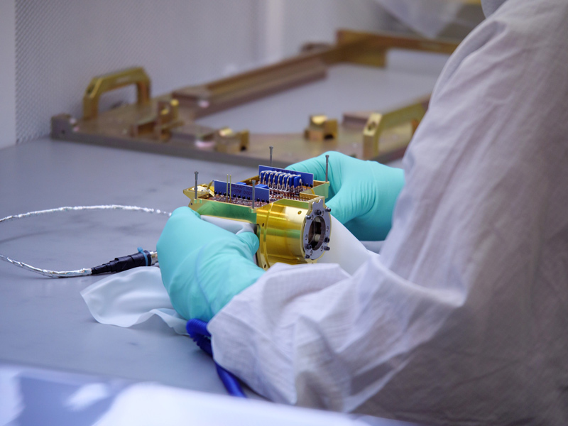 An image showing an engineer prepares the ion detector for integration to the SUrface Dust Analyzer (SUDA) sensor head at the Laboratory for Atmospheric and Space Physics (LASP) at the University of Colorado Boulder. SUDA is extremely sensitive and will be able to detect amino acids in concentrations as low as one part per million within water ice.