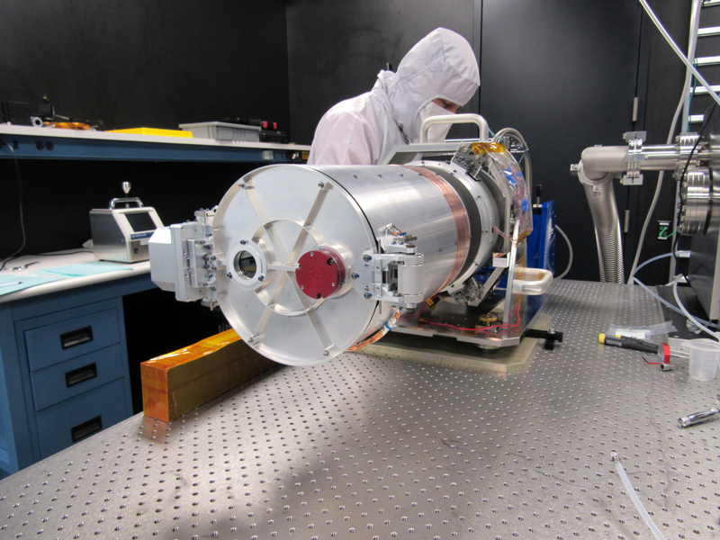 An engineer inspects the test setup of the optical telescope assembly for the Europa Imaging System narrow angle camera. 
