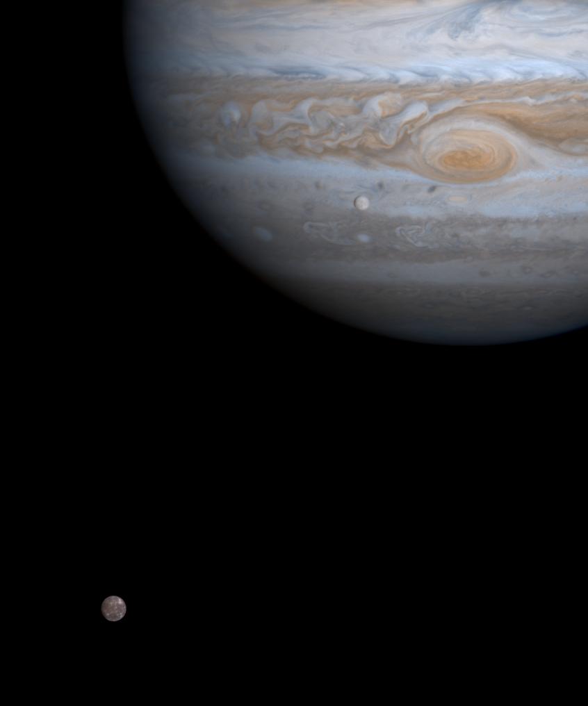 color view of two small moons and jupiter in black space