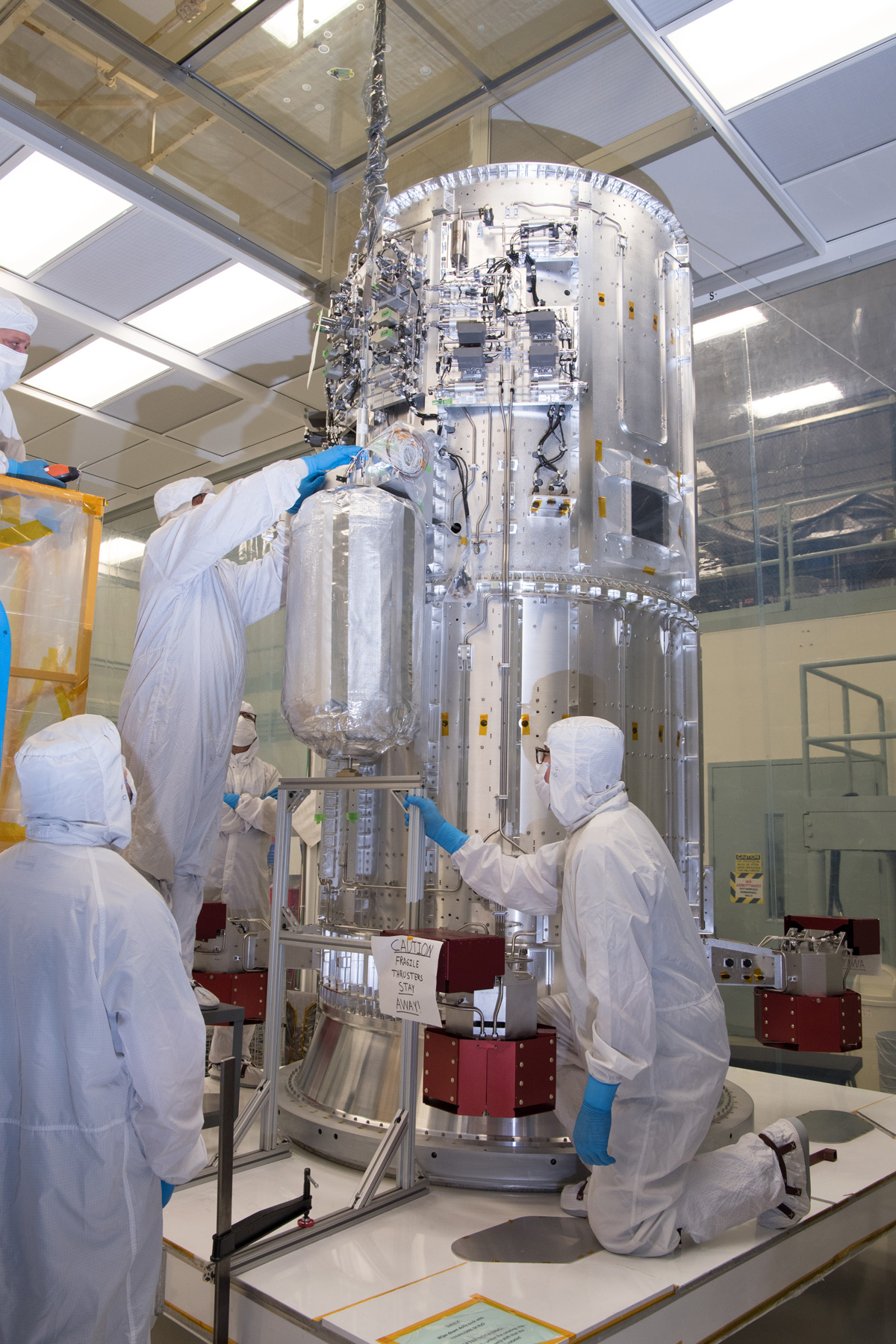 Engineers and technicians in a clean room at NASA's Goddard Space Flight Center in Greenbelt, Maryland, integrate the tanks that will contain helium onto the propulsion module of NASA's Europa Clipper spacecraft.