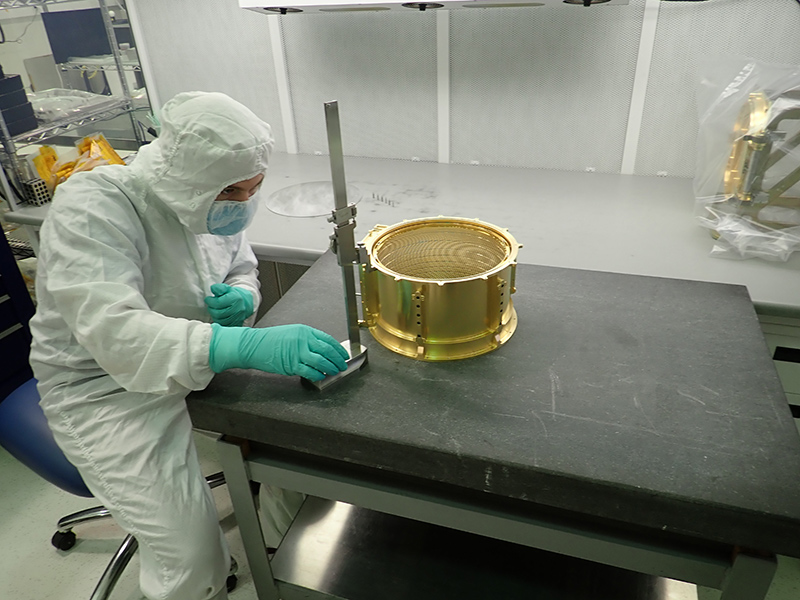 Marc Miller, a mechanical assembly technician at the University of Colorado Boulder Laboratory for Atmospheric and Space Physics (LASP), inspects the SUrface Dust Analyzer (SUDA) ion optics assembly. The optics will turn and focus the ions generated when hypervelocity dust particles strike SUDA’s metal target plate.
