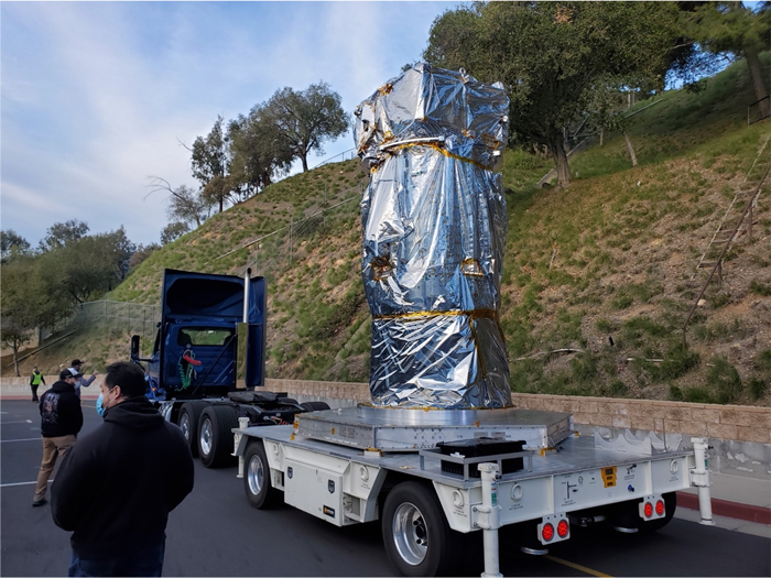 A shiny metal cylinder 5 feet (1.5 meters) wide and 16 feet (5 meters) tall stands erect on the flatbed of a truck.